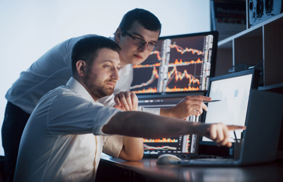 traders analyzing their performance in a funded trader program.